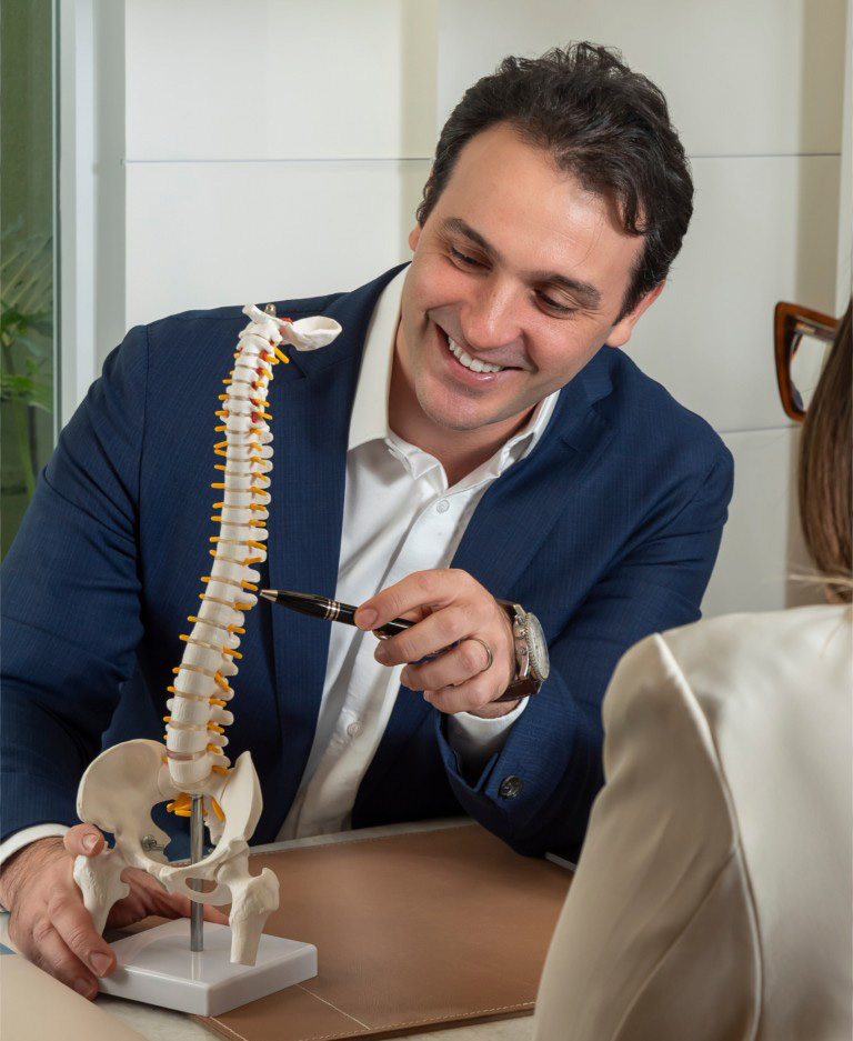 Dr. Bernardo Rivello tratando paciente com modelo de coluna